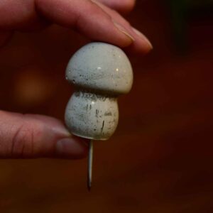 Beton-Pilz als Dekoration für Glasgärten mit Nagel zur Moosbefestigung, in der Hand gehalten für Größenvergleich – natürliche Mini-Deko für Terrarien.